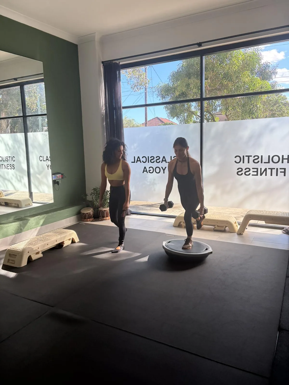 Group fitness class training on balance trainers by the window at Adiyoga in Earlwood