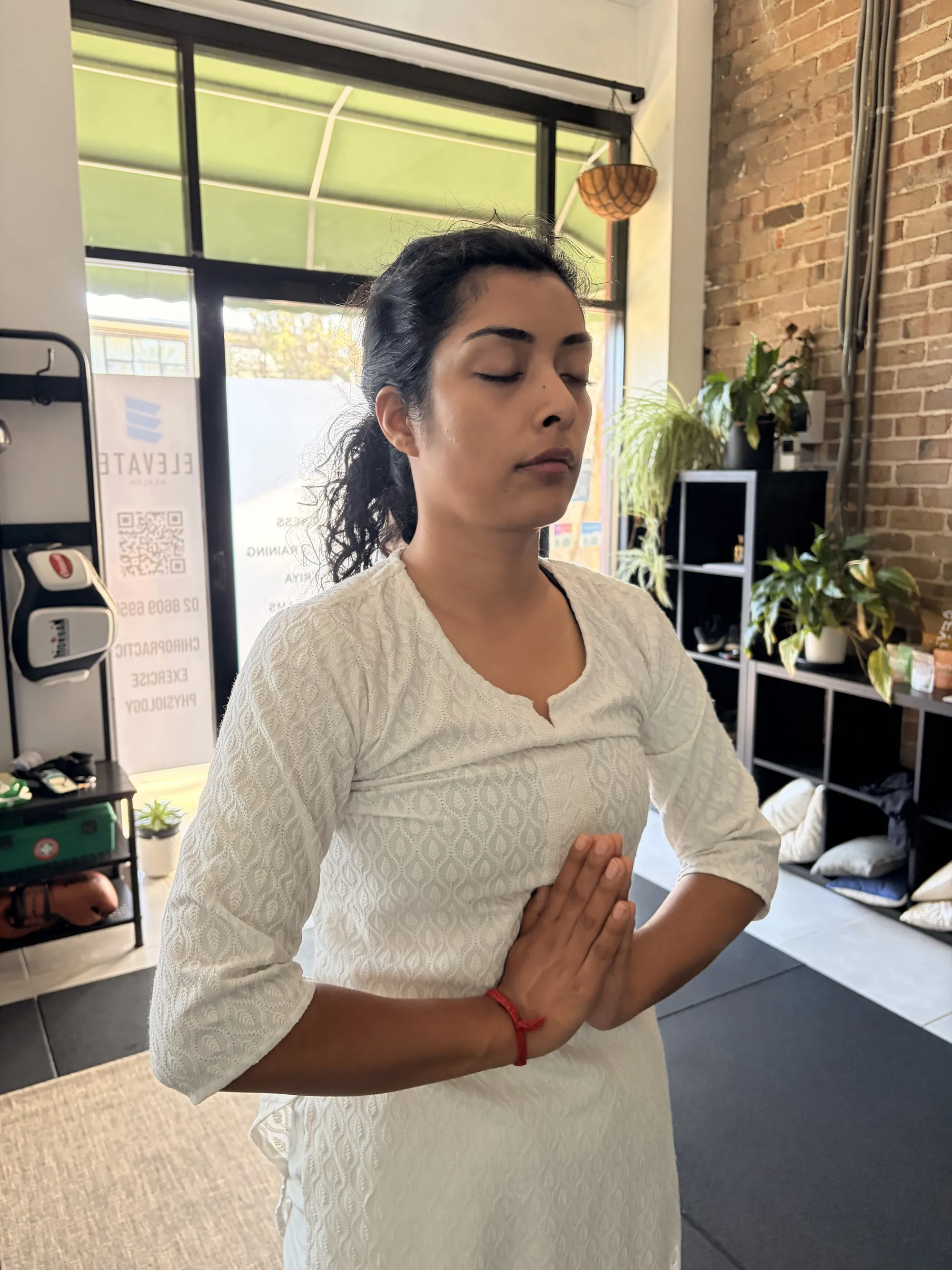 Student in a standing prayer pose during a yoga class at the Adiyoga studio in Earlwood
