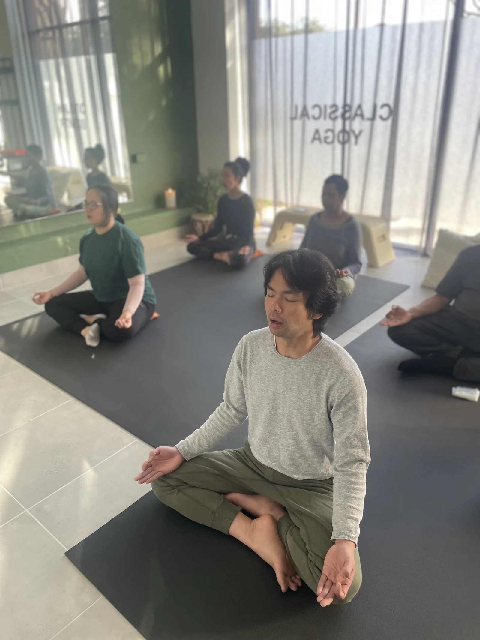 Teacher guiding a student one to one during a yoga class at Adiyoga in Earlwood